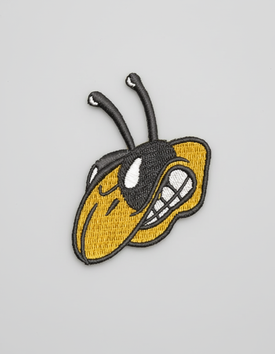 Bee embroidery patch featuring a stylized yellow and black bee head with long antennae and bold outlined stitching, on a light background, original EmbroMania artwork.