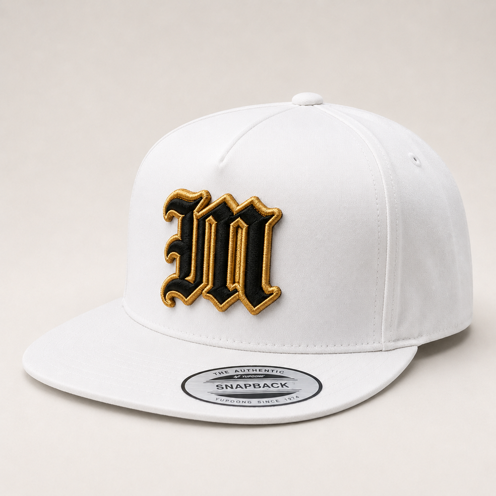 White snapback cap with gold and black logo on a light gray background