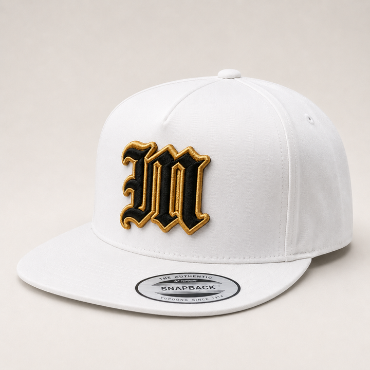 White snapback cap with gold and black logo on a light gray background