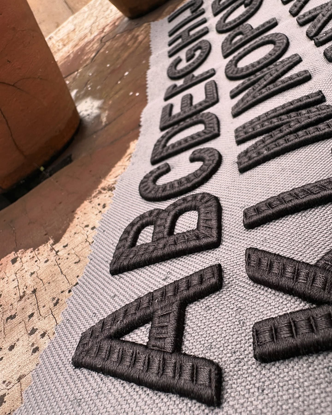 Textured mat with black letters on a wooden floor