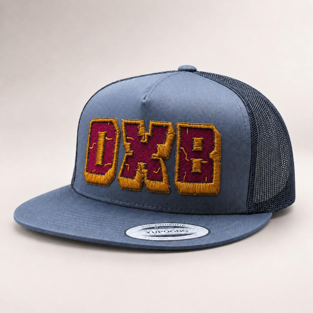 Blue trucker cap with embroidered letters on a light gray background