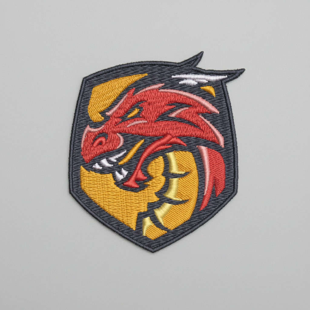 Crimson wyrm crest embroidery patch featuring a fierce red dragon head on a dark shield-shaped emblem with gold accents and bold border stitching, on a light background, original EmbroMania artwork.