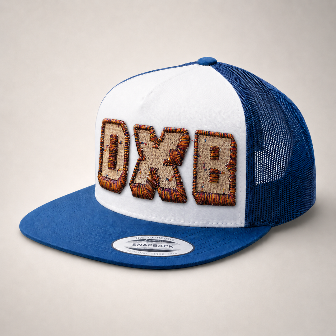 Blue and white cap with embroidered letters on a light gray background