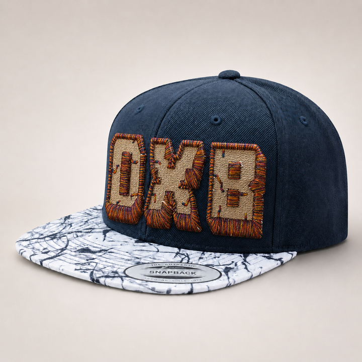 Blue snapback cap with brown and beige text design on a marble-patterned brim against a beige background