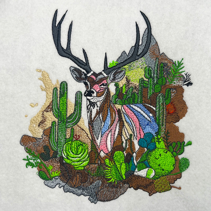 Embroidered jute tote bag featuring a mountain buck and cactus garden design.
