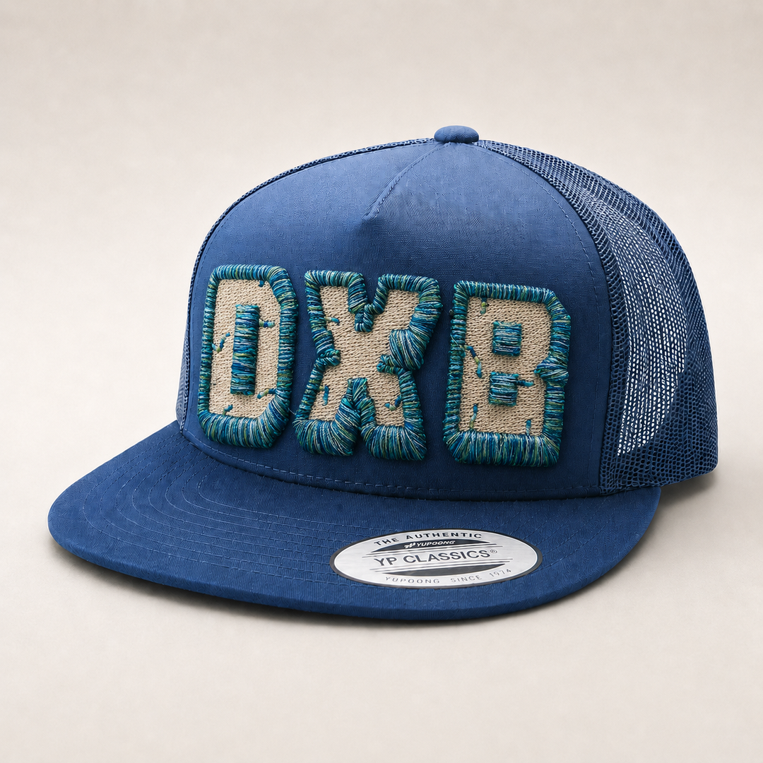 Blue cap with embroidered letters on a light background