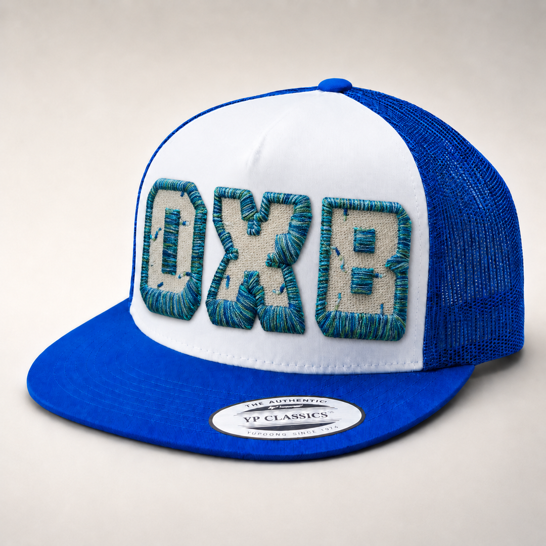 Blue and white cap with embroidered text on a light gray background