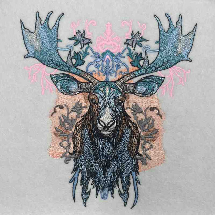 Embroidered moose head design on a beige jute tote bag, featuring intricate antlers with metallic thread accents and botanical motifs.