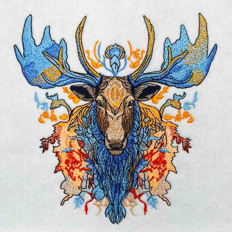 Embroidered jute tote bag featuring a detailed and colorful moose design amidst foliage and geometric patterns.