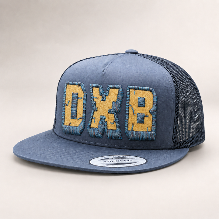 Blue trucker cap with yellow text on a light gray background