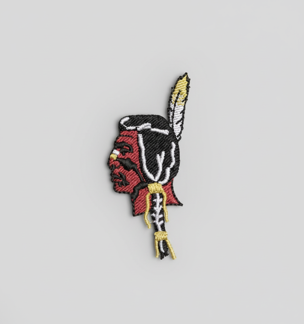 Embroidered patch of an Native American head with a feather on a grid background