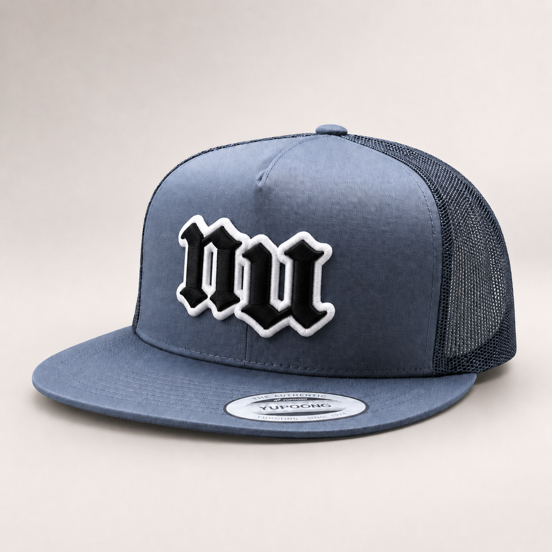 Blue trucker cap with black and white logo on a light gray background