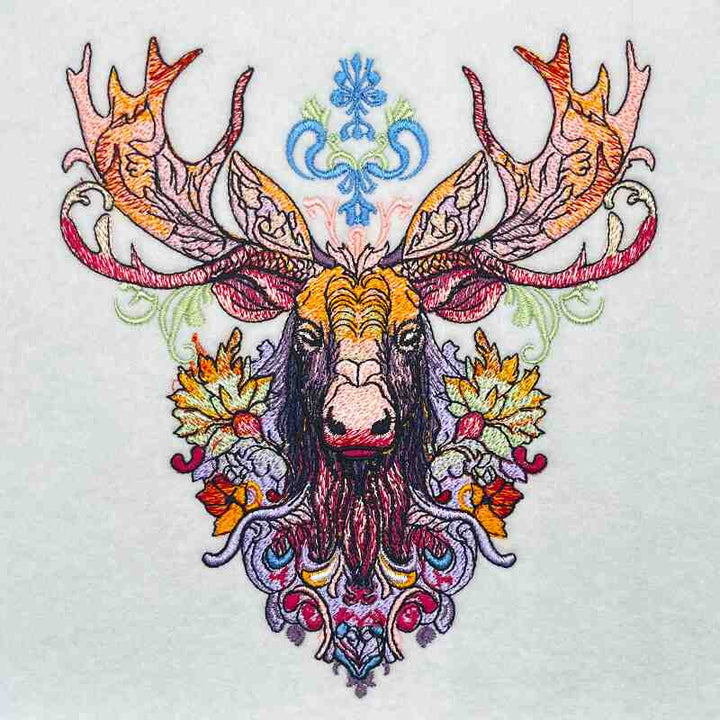 A jute tote bag with a vibrant and intricate embroidered moose design on the front.