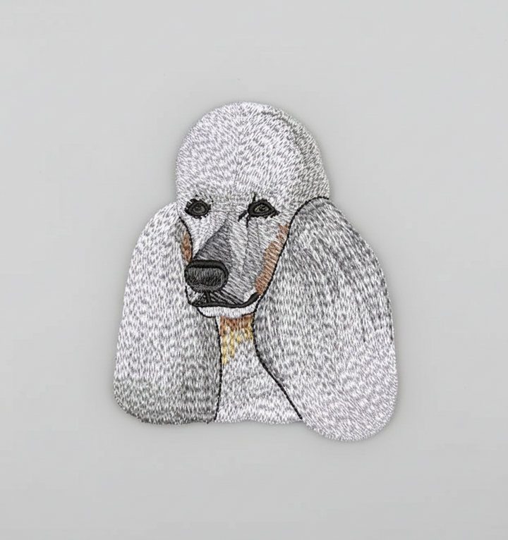 Realistic poodle embroidery patch featuring a detailed dog portrait with fluffy white coat, long ears, and soft gray shading, stitched with textured thread on a light background, original EmbroMania artwork.