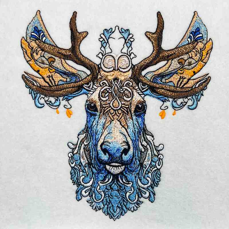 Embroidery of a deer with intricate floral patterns on a beige jute tote bag.