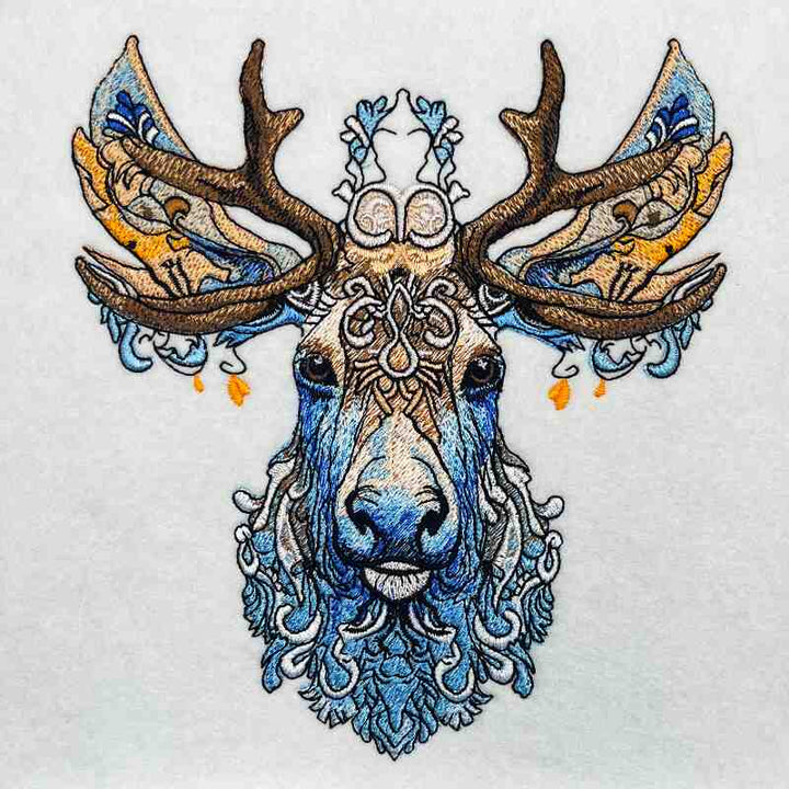 Embroidery of a deer with intricate floral patterns on a beige jute tote bag.