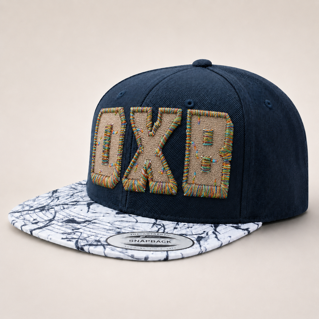 Navy blue cap with decorative patch and marble-patterned brim on a beige background
