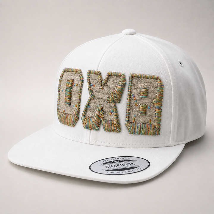 White cap with embroidered text on a light gray background