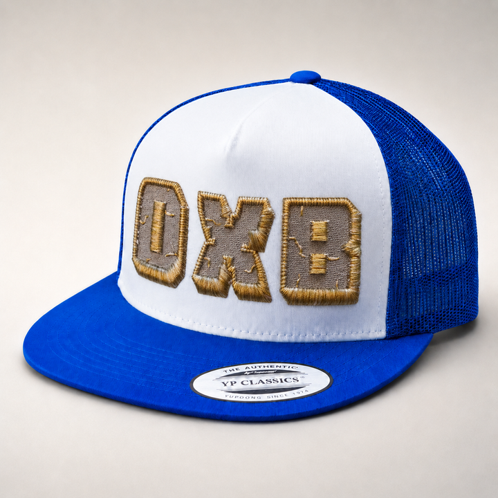 Blue and white cap with embroidered letters on a light gray background