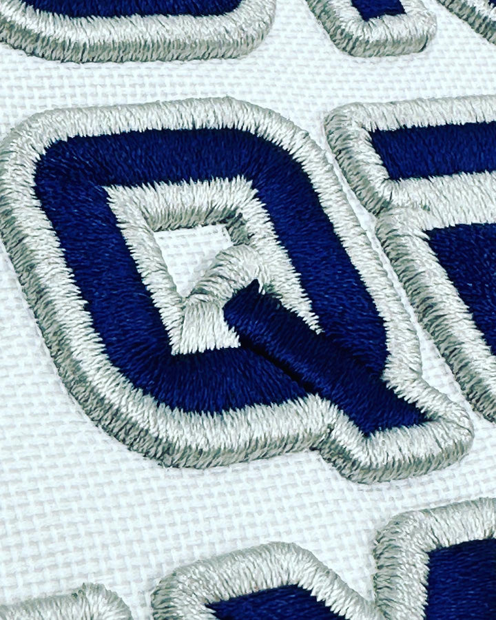 Close-up of embroidered blue and white patches with a geometric design.
