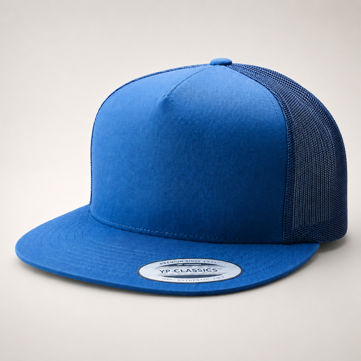 Blue trucker cap with mesh back on a light gray background