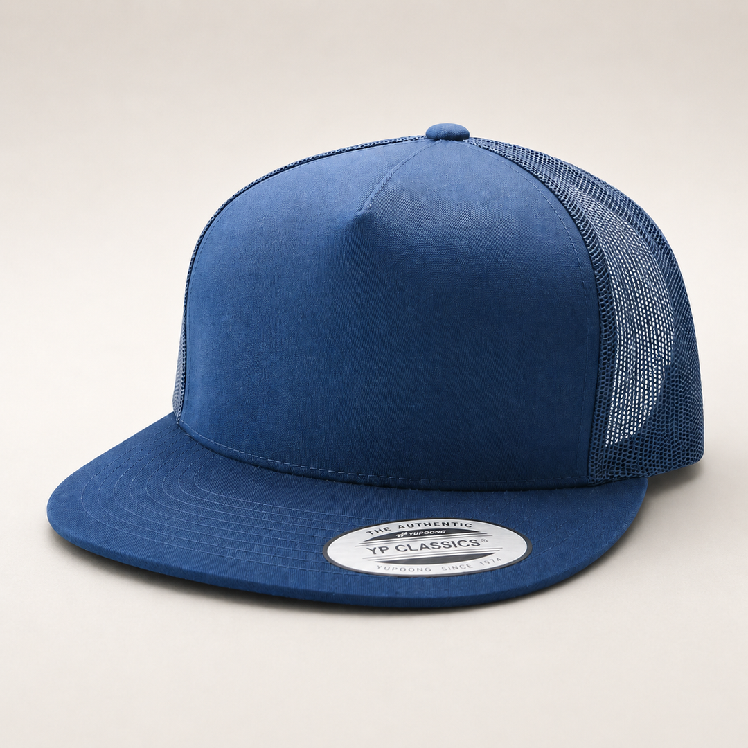 Blue trucker cap with mesh back on a light gray background