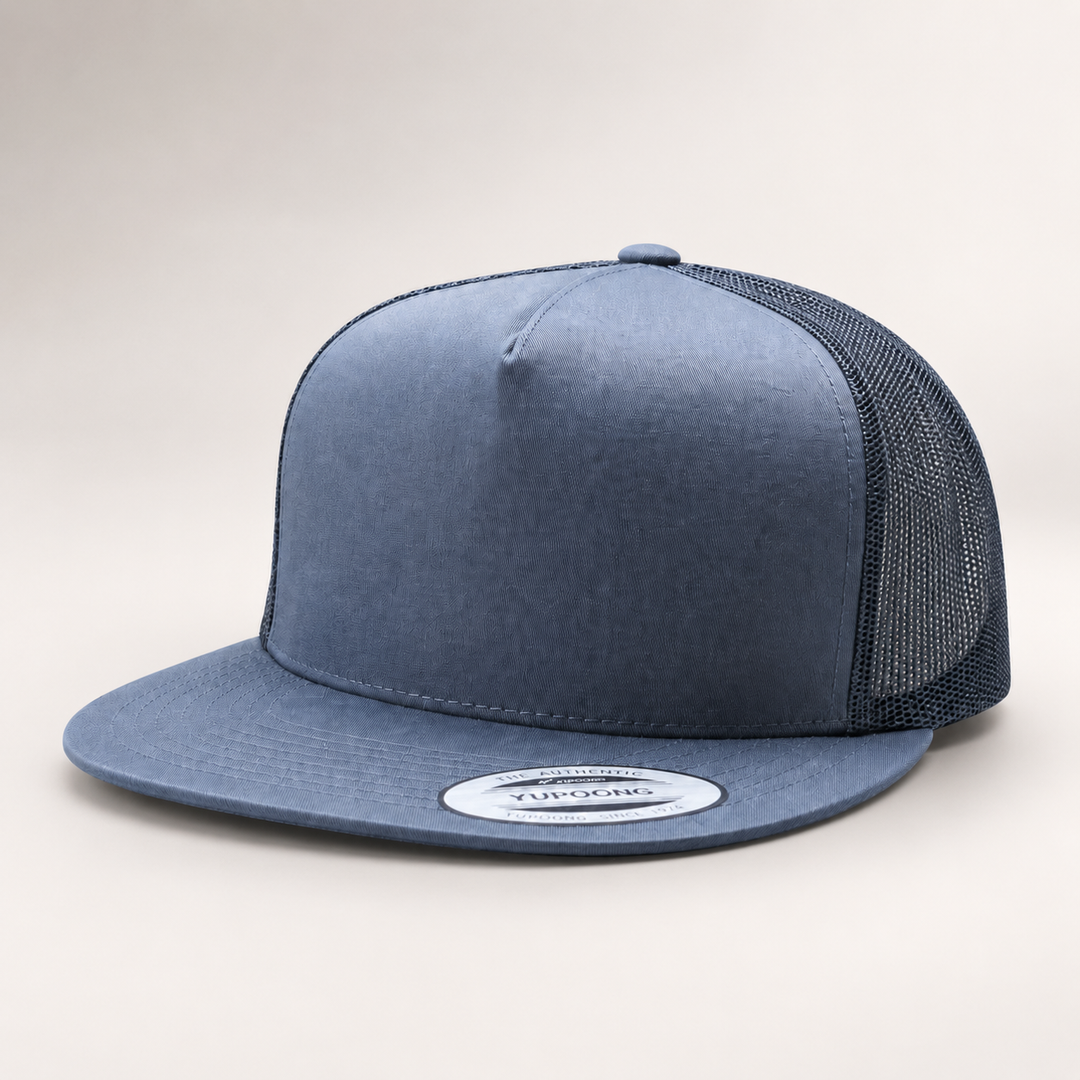Blue trucker cap with mesh back on a light gray background