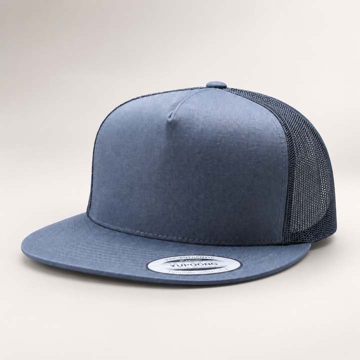 Blue trucker cap with mesh back on a light gray background