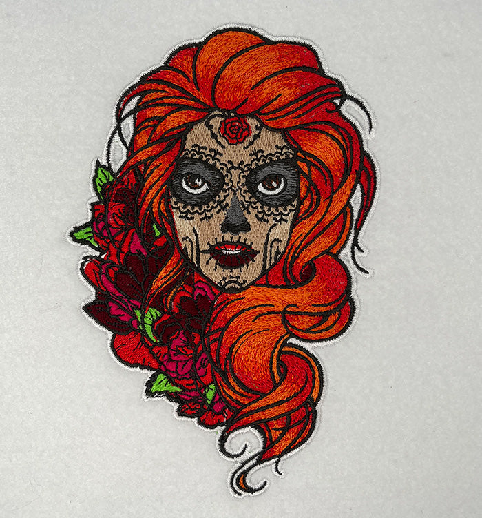 Embroidered jute tote bag featuring a whimsical character with red hair and floral elements.