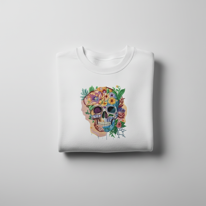 White sweatshirt with a colorful skull and floral design on a light gray background