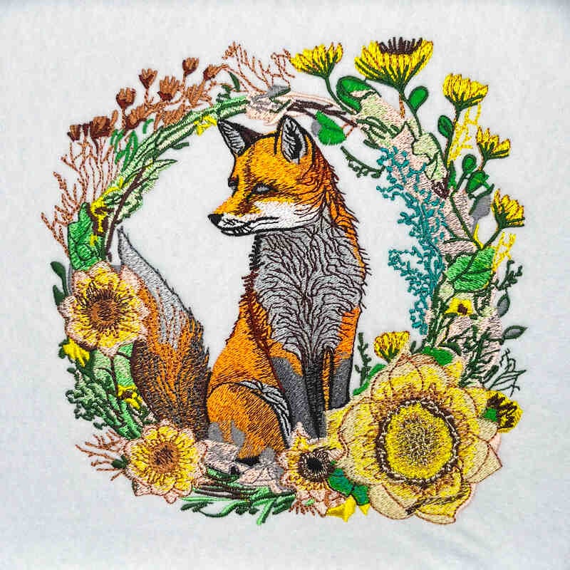 Embroidered design of a fox surrounded by flowers on a white background