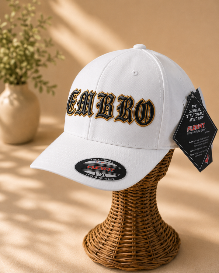 ⭐ Black Gold – Old English 3D Puff · Black fill · Gold puff outline · White Flexfit curved | Hand Finished in Dubai | EmbroMania